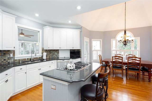 kitchen featuring a sink, stainless steel appliances, a breakfast bar, and a healthy amount of sunlight