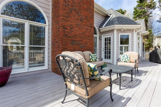 wooden terrace with area for grilling and an outdoor hangout area