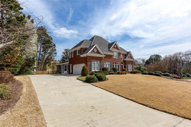 view of front of property featuring concrete driveway, an attached garage, brick siding, and a front yard