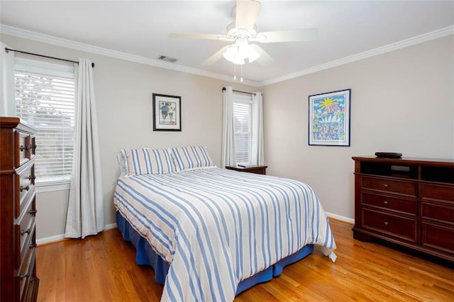 bedroom featuring light wood-style flooring, crown molding, and multiple windows