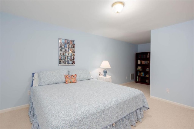 bedroom featuring visible vents, baseboards, and light colored carpet