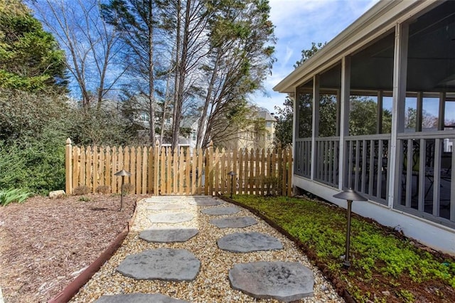 view of yard featuring fence and a sunroom