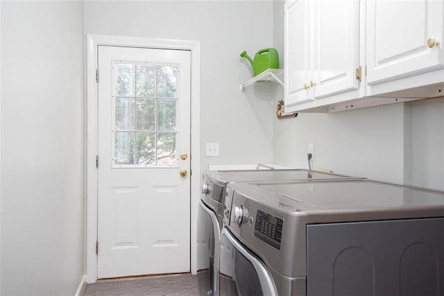 laundry area with baseboards, cabinet space, and washer and clothes dryer