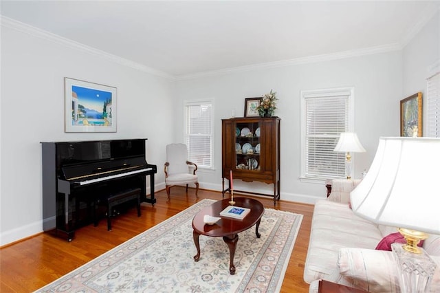 living room with crown molding, baseboards, and light wood finished floors