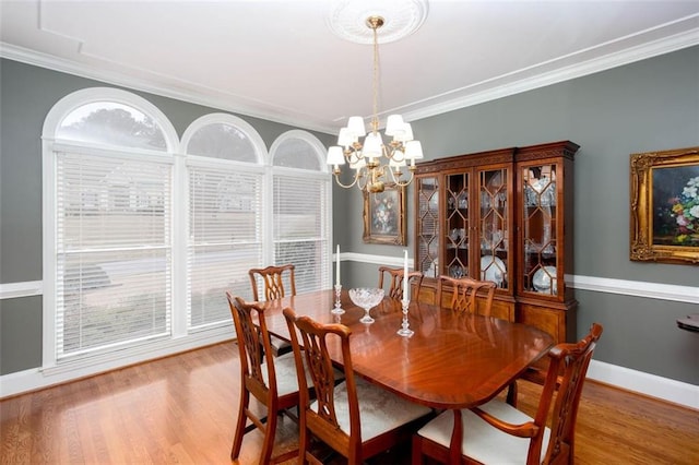 dining area featuring a chandelier, wood finished floors, and ornamental molding