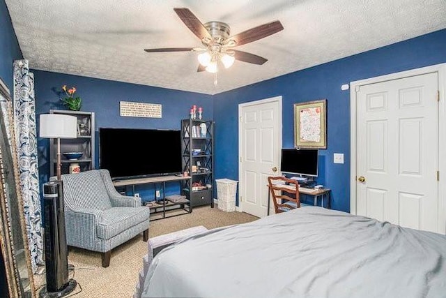 bedroom featuring carpet flooring, a textured ceiling, and ceiling fan