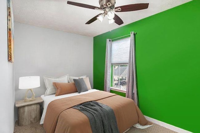 carpeted bedroom featuring a textured ceiling and ceiling fan