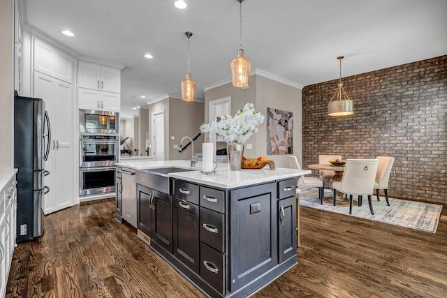 1120 Cordia Ave NW, Atlanta, GA 30318 - kitchen featuring appliances with stainless steel finishes, a sink, brick wall, white cabinets, and dark wood-style flooring