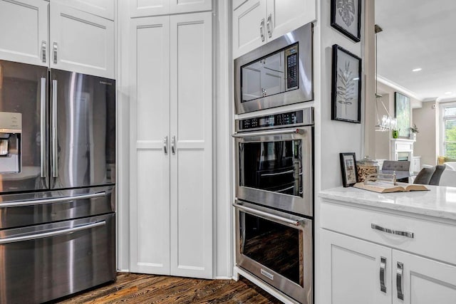 1120 Cordia Ave NW, Atlanta, GA 30318 - kitchen with appliances with stainless steel finishes, light stone counters, dark wood finished floors, white cabinetry, and recessed lighting
