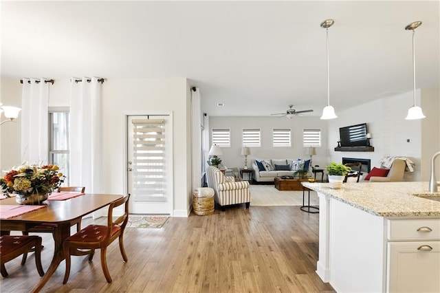 kitchen featuring ceiling fan, a sink, healthy amount of natural light, and light wood finished floors