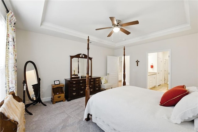 bedroom featuring a raised ceiling, light carpet, connected bathroom, a ceiling fan, and baseboards