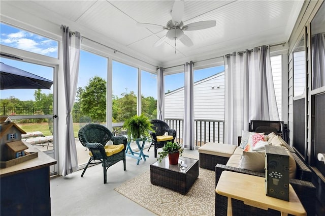 sunroom featuring ceiling fan and an outdoor living space