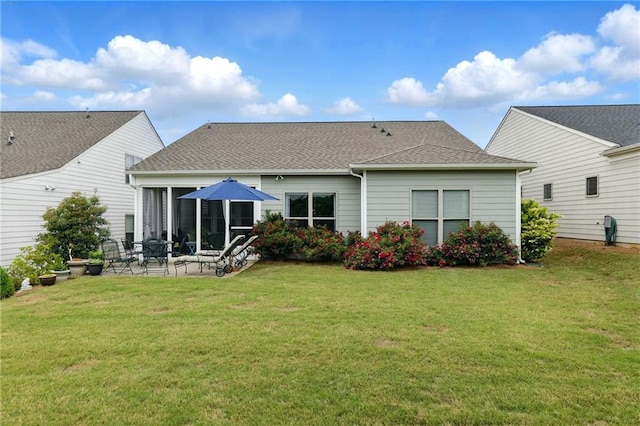 back of property featuring a sunroom, a yard, a patio, and a shingled roof