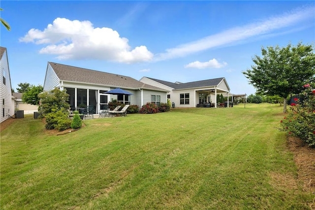 rear view of house with a lawn and central AC unit