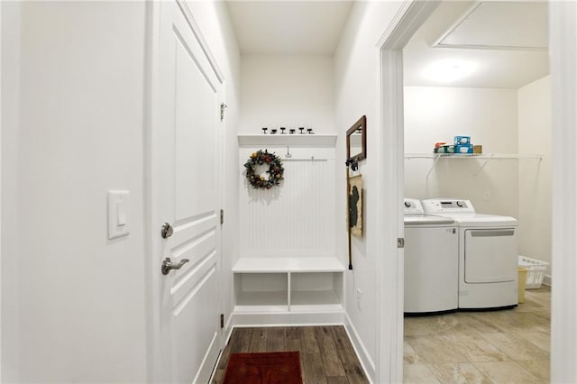 mudroom featuring washing machine and clothes dryer, baseboards, and wood finished floors