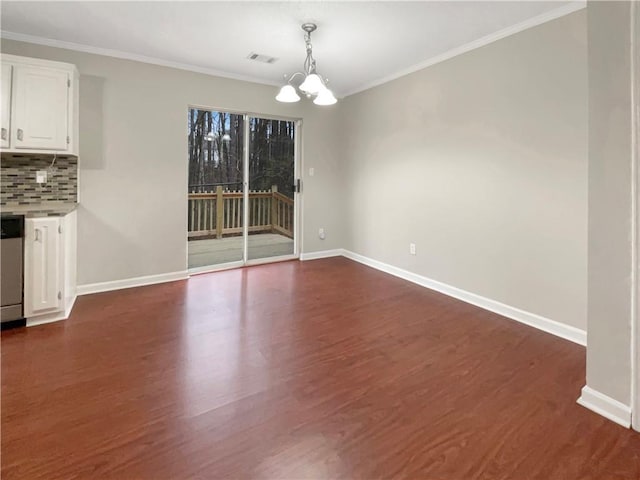 unfurnished dining area featuring dark hardwood / wood-style flooring, ornamental molding, and a notable chandelier