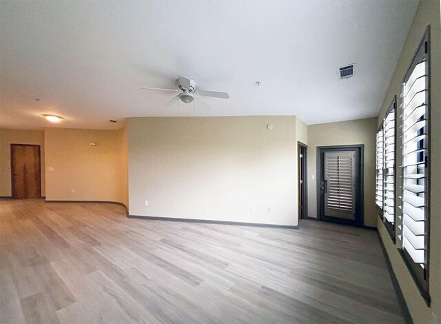 empty room with light wood-type flooring and ceiling fan