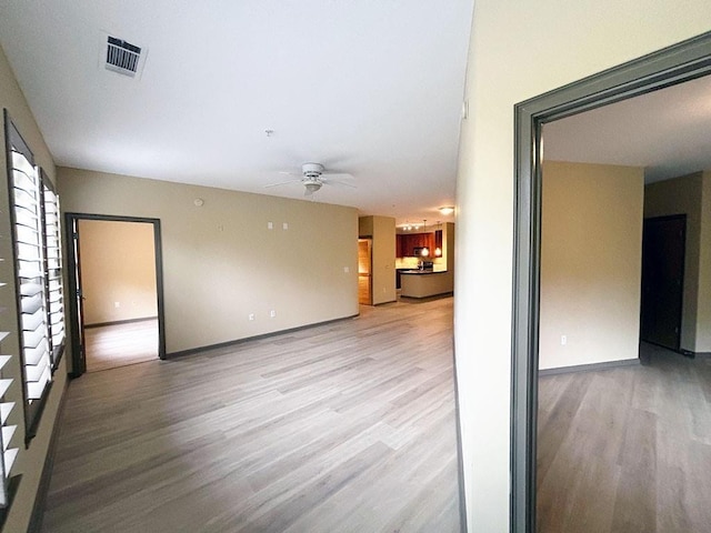 empty room featuring ceiling fan and light hardwood / wood-style flooring