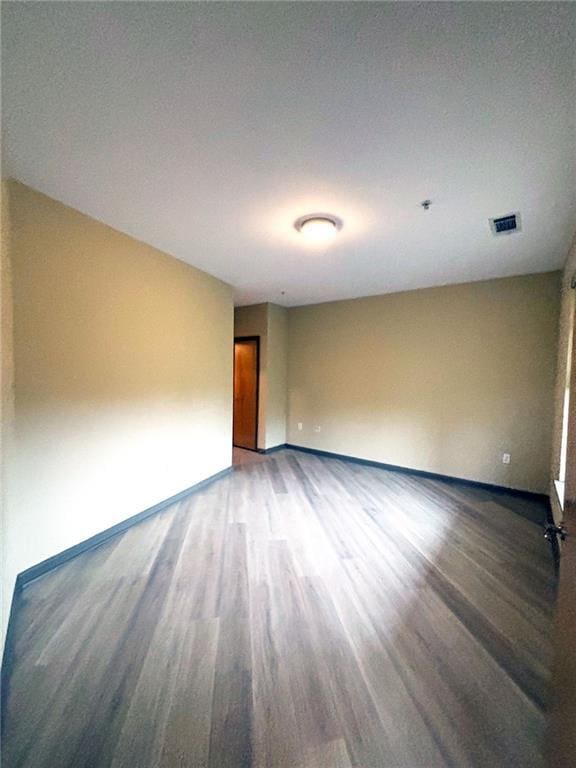 empty room with hardwood / wood-style floors and a textured ceiling