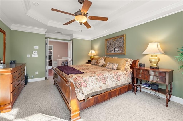 carpeted bedroom featuring ceiling fan, a tray ceiling, and ornamental molding