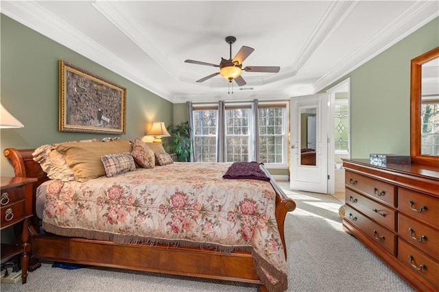 carpeted bedroom with a raised ceiling, ceiling fan, and crown molding