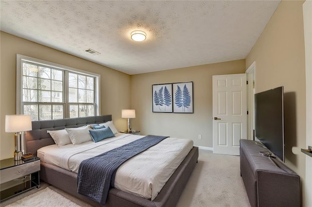 bedroom featuring light carpet and a textured ceiling