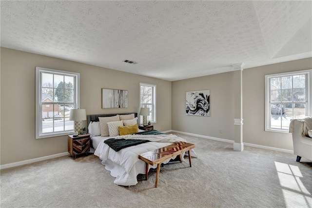 bedroom featuring light carpet and a textured ceiling