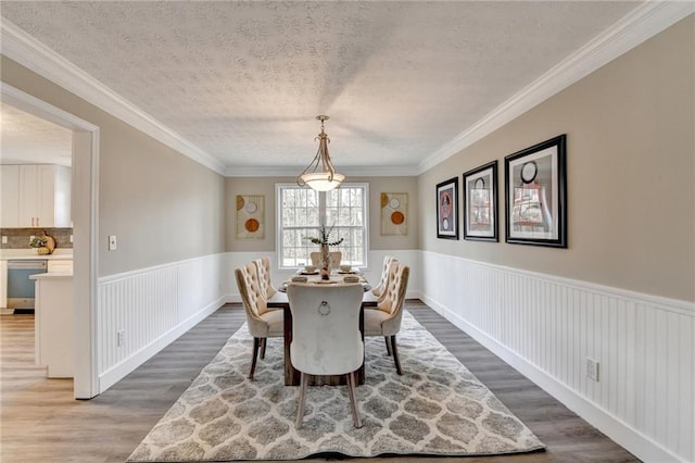 dining area with crown molding, dark hardwood / wood-style floors, and a textured ceiling