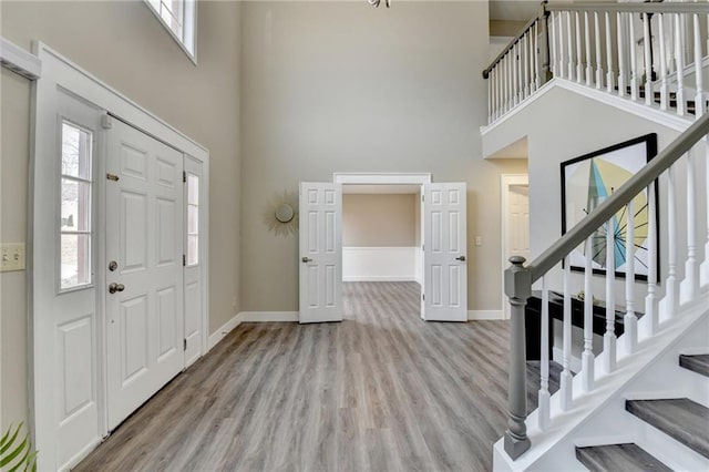 entrance foyer featuring a towering ceiling and light hardwood / wood-style floors