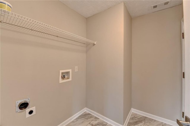 clothes washing area with hookup for a washing machine, hookup for an electric dryer, and a textured ceiling