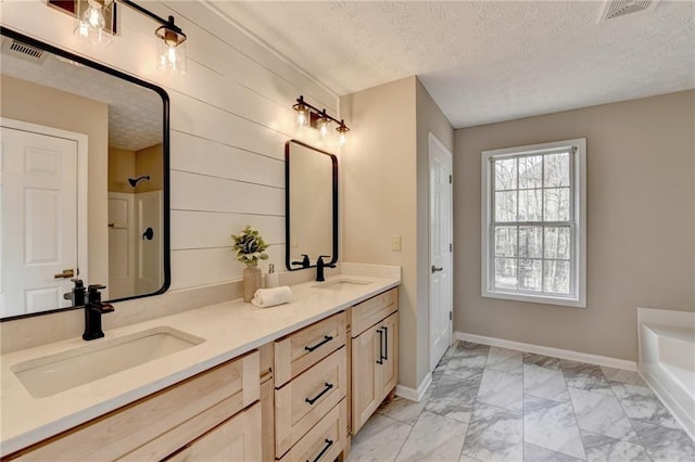 bathroom featuring vanity, independent shower and bath, and a textured ceiling