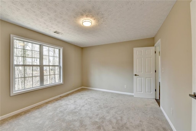 unfurnished room featuring light carpet and a textured ceiling