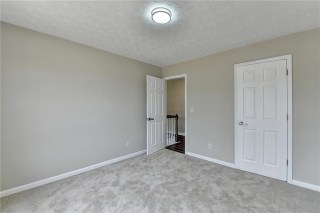 unfurnished bedroom featuring light colored carpet and a textured ceiling