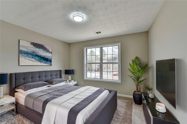 bedroom featuring a textured ceiling and carpet flooring