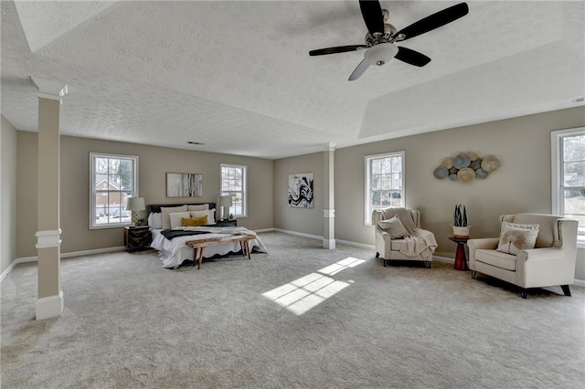 bedroom featuring light colored carpet, a textured ceiling, and ornate columns