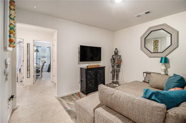 bedroom with baseboards, visible vents, and light carpet