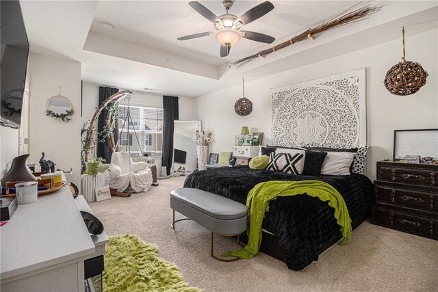 bedroom featuring carpet floors, a ceiling fan, and a tray ceiling