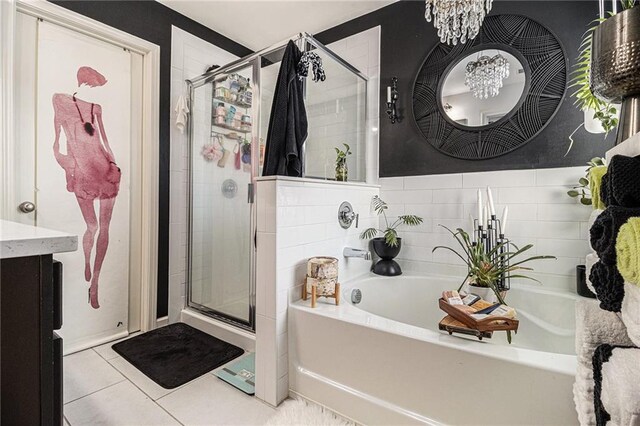 full bath featuring a notable chandelier, vanity, tile patterned floors, a shower stall, and a bath