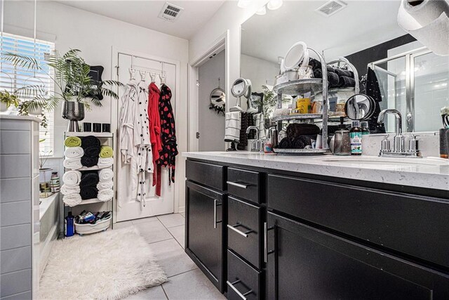 full bathroom featuring a sink, tile patterned floors, a stall shower, and visible vents
