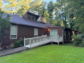 back of house with a lawn and a deck