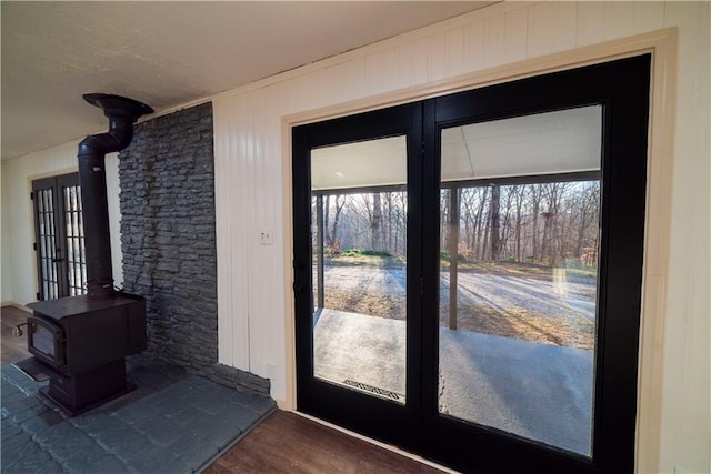 doorway with dark wood-style flooring and a wood stove