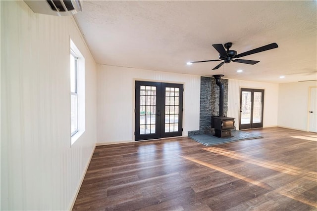 unfurnished living room with french doors, a textured ceiling, a healthy amount of sunlight, and wood finished floors