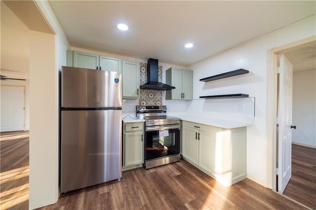 kitchen with dark wood finished floors, stainless steel appliances, light countertops, wall chimney range hood, and backsplash