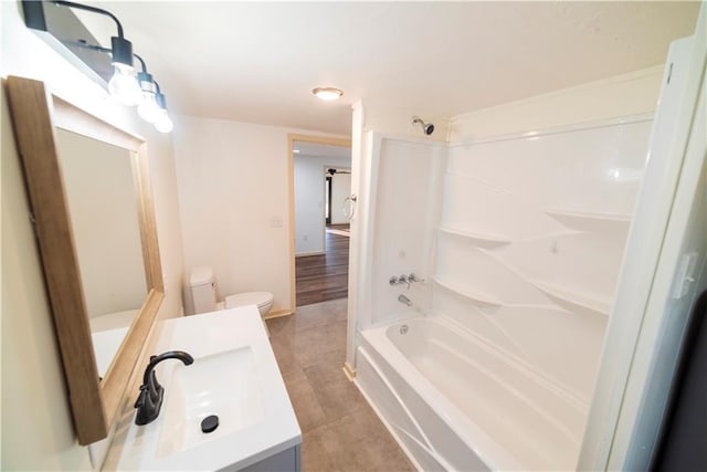 bathroom with tile patterned flooring, toilet, tub / shower combination, and vanity