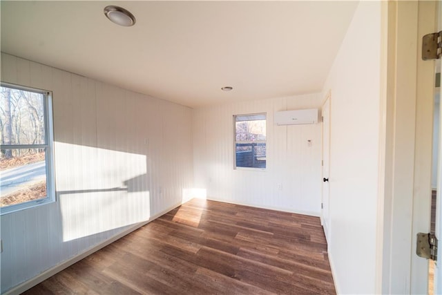 spare room with wood finished floors and a wall mounted air conditioner