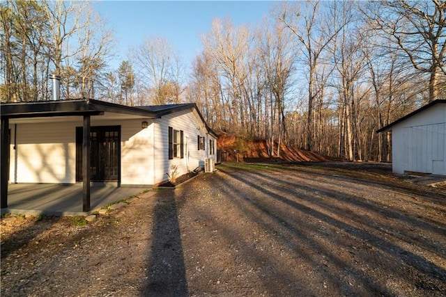 view of side of property featuring dirt driveway