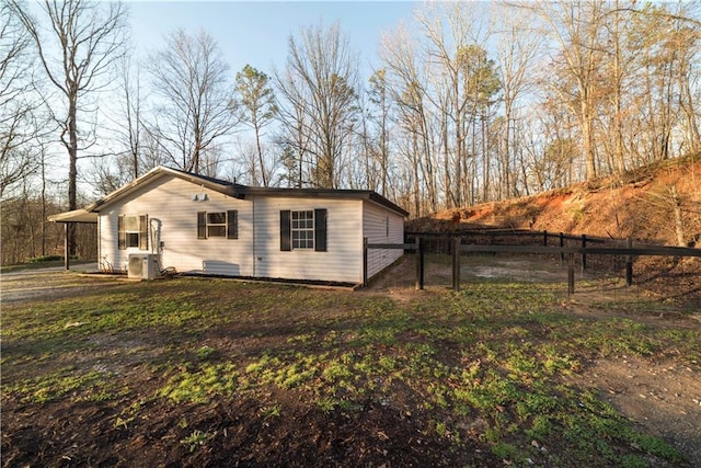 view of property exterior featuring fence and central AC