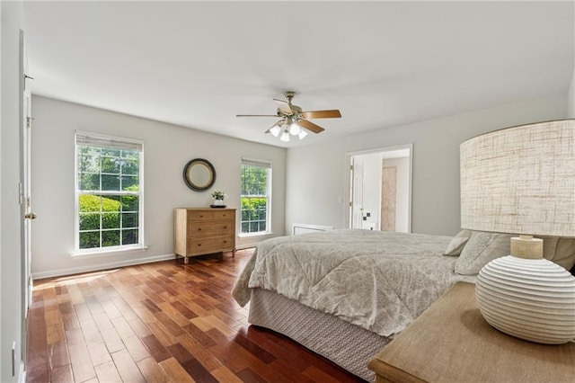 bedroom with a ceiling fan, baseboards, and wood finished floors