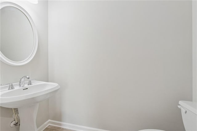 half bath with toilet and baseboards