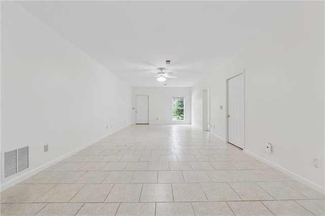 empty room with baseboards, ceiling fan, and visible vents